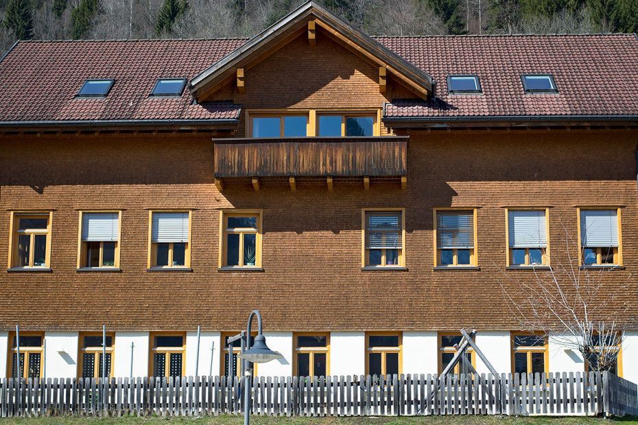 Ein großes Holzgebäude mit einem Zaun darum
