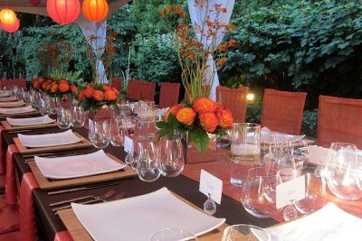 A long table with plates glasses and flowers on it